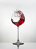 Red wine spattering out of a glass