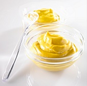 Mustard in a glass dish with a spoon