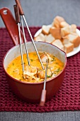 Cheese fondue with herbs and bread cubes