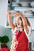 Germany, Girl playing with spaghetti