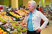 Germany, Cologne, Mature woman thinking in supermarket