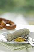 Plate with Bavarian veal sausage with mustard and pretzel