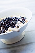 Cake batter with black currants in a bowl