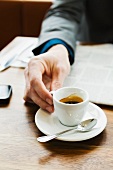 A businessman drinking espresso in a café