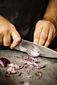 A man cutting a red onion