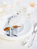 Christmas place setting with a cinnamon stick and an ostrich feather