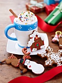 A Mug of Hot Chocolate with Whipped Cream and Sprinkles with Decorated Christmas Cookies