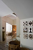 Large wicker baskets on floor of foyer next to gallery of artworks; dog in front of open doorway leading to living room in background