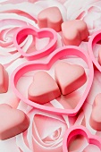 pink chocolate love hearts with heart shaped cookie cutters on a pastel rose pattern