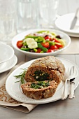 Meatloaf made from beef and stuffed with spinach and pine nuts