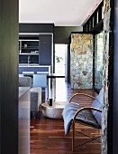 Offener Wohnraum in dezenten Grautönen und Natursteinquader im Kontrast zu anthrazitfarbenen Wänden