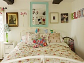 Romantic bedroom with wall mirror above bed, bunting and pictures on wall