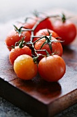 Tomatoes on the vine on a wet wooden board