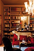 Grand library with integrated wall mirror, leopard skin on back of sofa and crystal chandelier