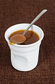 Caramel sauce in a pot with a spoon