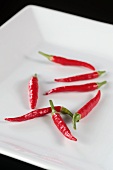 Several fresh red chillies on a plate