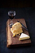 A still life of cheese and red wine