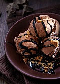 Several scoops of chocolate ice cream with chocolate sauce