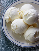 Several scoops of vanilla ice cream on a plate (view from above)