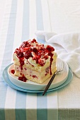 A piece of raspberry ice cream layer cake with cream and raspberry sauce