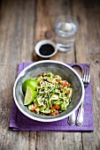 Raw courgette spaghetti with tomatoes, sesame seeds and limes