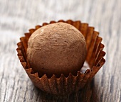 Close up of chocolate truffle on brown wooden table