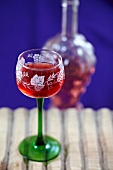 Rotweinglas auf altem Holzbrett und Weinflasche