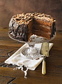 Removing Slice of Classic Chocolate Cake on Pedestal Dish