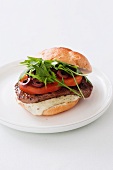 A burger with rump steak, tomatoes, olives and rocket (Italy)