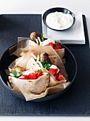Pita breads stuffed with chicken, sausages and tomatoes