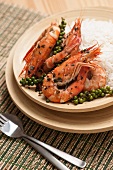 Stir-fry king prawns with garlic, fresh green peppers and basil, served with jasmin rice on a bamboo plate. This Kampot green pepper prawns is a Cambodian traditional dish.