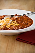 A Bowl of Beef Chili with Sour Cream and Shredded Cheese