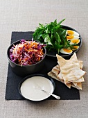 Coleslaw, herbs, hard-boiled eggs, flatbread and a dip