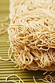 Chinese egg noodles on a bamboo mat (close-up)