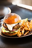 Hamburger with Mayo Sauce, Lettuce and Onion on a Poppy Seed Bun, Served with French Fries