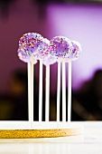Purple Frosted Cake Pops with Rainbow Colored Sprinkles