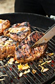 Turning Marinated Lamb Meat Over on a Charcoal Grill