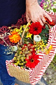 Frau trägt Tasche mit Sommerblumen im Garten