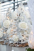 Christmas trees made from white twigs with white roses and fairy lights