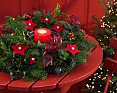 Advent wreath with candle and red felt stars on wooden table