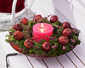 Winter wreath of brunia and heather with apples and candle
