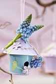 Spring arrangement of tiny blue bird box and grape hyacinths