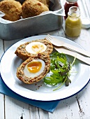A Scotch egg with salad leaves
