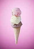 An ice cream cone with strawberry, vanilla and chocolate ice cream