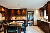 Küche im Landhausstil mit Massivholzfront in dunkelbrauner Farbe und Esstisch mit Marmorplatte
