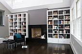 Elegant interior with fireplace flanked by white shelving contrasting with grey walls and dark wood floor