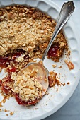 Strawberry jam topped with oat crumble in a casserole dish