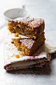 Two slices of carrot cake dusted with icing sugar