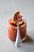 Harissa in a jar with a spoon
