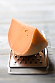A wedge of Mimolette cheese on a cheese grater